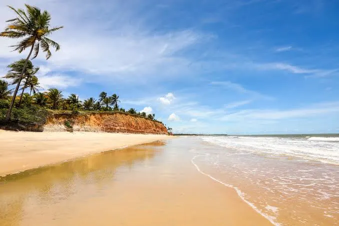 Praia de Cumuruxatiba com falésias e coqueiros