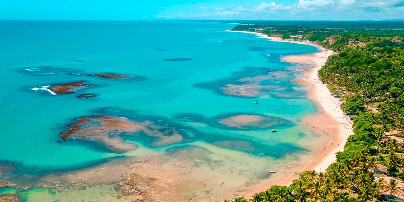 Vista aérea do litoral e das águas azuis de Trancoso